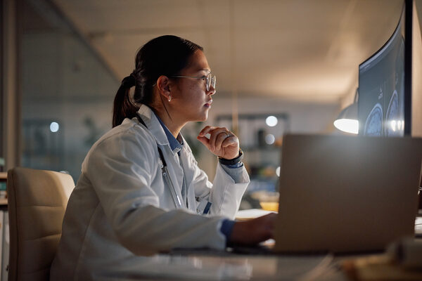 Women in medical coat looking at computer