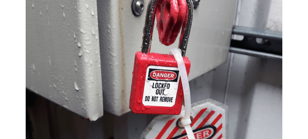 A machine in a factory with a red lockout tag.